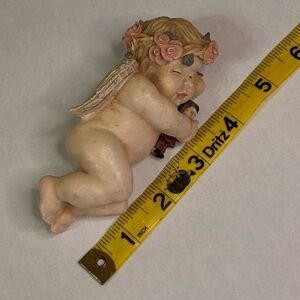 Sleeping Cherub Figurine holding a doll with Floral Crown